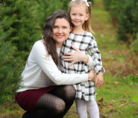 Mom hugging daughter in Christmas tree farm scaled 1 Mom hugging daughter in Christmas tree farm scaled 1