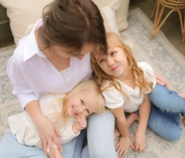 Mother sitting with children on floor during cozy family moment Mother sitting with children on floor during cozy family moment