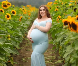 Pregnant woman standing alone in sunflower field portrait Pregnant woman standing alone in sunflower field portrait