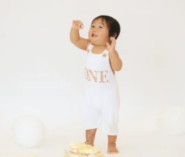 Toddler standing proudly after cake smash session