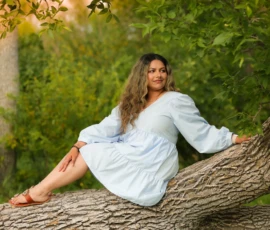 Woman sitting on fallen tree during outdoor portrait