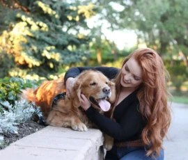 Woman sitting on path holding dog during outdoor portrait