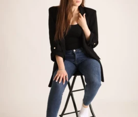 Woman sitting on stool posing in studio portrait