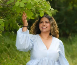 Woman standing confidently outdoors in white dress
