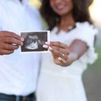 Expecting couple holding ultrasound photo during outdoor maternity photography session.jpg Expecting couple holding ultrasound photo during outdoor maternity photography session.jpg